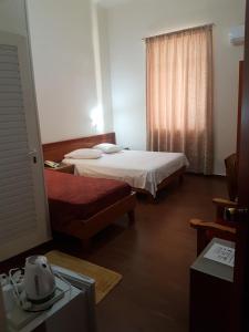 A bed or beds in a room at Lena Hotel