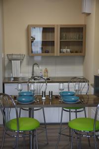 uma cozinha com uma mesa com 4 cadeiras e um lavatório em Apartament Tabaco em Lódź