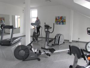 une femme dans une salle de sport avec plusieurs vélos d'exercice dans l'établissement Ostsee Mobilheime Heideby, à Waabs