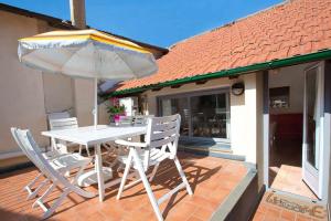 a table and chairs with an umbrella on a patio at Casa del Sole in Finale Ligure