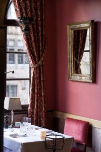 a dining room with a table and a mirror at Hotel Duc De Bourgogne in Bruges