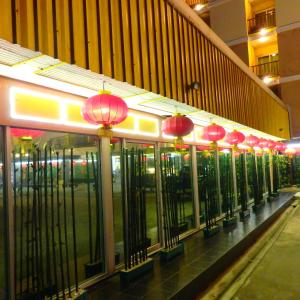 uma linha de lanternas vermelhas no lado de um edifício em Pohseen Grand Palace Hotel em Bang Na