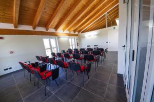 Cette chambre dispose de chaises, de tables et de plafonds en bois. dans l'établissement Agriostello delle Langhe, à Farigliano