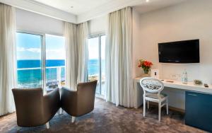 a hotel room with a desk and a large window at Hotel Farah Tanger in Tangier