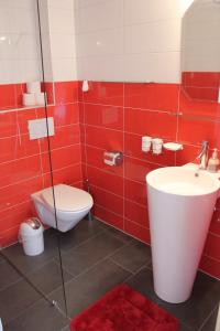a red bathroom with a toilet and a sink at BNB Les Prises in Les Ponts-de-Martel