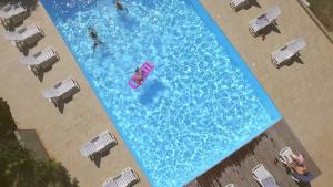 an overhead view of people in a large swimming pool at Lavu Santu in Sainte-Lucie de Porto-Vecchio