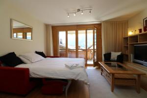 ヴェンゲンにあるChalet Bella Vista 3のベッドルーム1室(ベッド1台付)、リビングルーム(テレビ付)