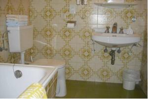 a bathroom with a toilet and a sink at Hotel Posthof in Millstatt