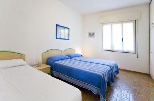 een slaapkamer met twee bedden en een raam bij Angela in Bibione
