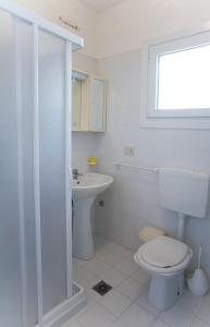 een witte badkamer met een toilet en een wastafel bij Angela in Bibione