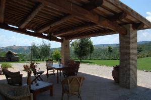 eine Terrasse mit einem Tisch und Stühlen unter einer hölzernen Pergola in der Unterkunft Villa Solaria in Orvieto