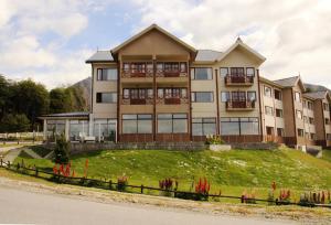 un gran edificio en la cima de una colina con césped en Altos Ushuaia Hotel & Resto en Ushuaia