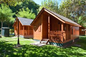 a small wooden cabin in a field of grass at Bungalows Verneda Mountain Resort in Arrós