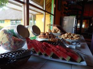 un buffet con sandía y otros alimentos en una mesa en Sotavento Apart Hotel, en La Paloma