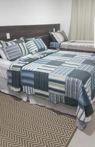dos camas sentadas una al lado de la otra en un dormitorio en Le Bon Vivant 203, en Arraial do Cabo