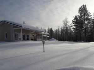 a snow covered parking lot with a building at Ristijärven Pirtti Cottage Village in Ristijärvi