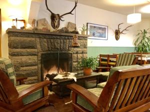a living room with a fireplace and rocking chairs at Hotel Turismo in San Martín de los Andes
