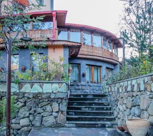 a house with a stone wall and stairs in front at Hotel Mirhav in Goris