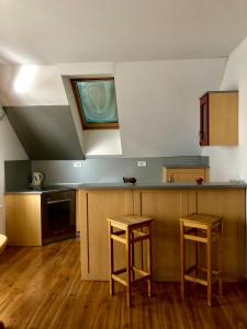 a kitchen with a counter and two stools at Apartmaji Zlata Lisička in Cerkno
