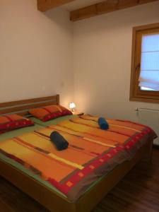 a bedroom with a large bed with two pillows at Apartmaji Zlata Lisička in Cerkno