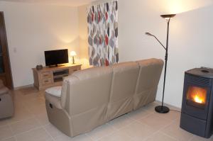 ein Wohnzimmer mit einem Sofa und einem Kamin in der Unterkunft Holiday home La ferme brabant in Voeren