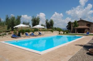 einen Pool mit 2 Stühlen und Sonnenschirmen in der Unterkunft Villa Solaria in Orvieto