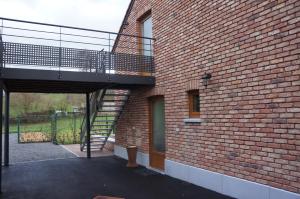 a brick building with a staircase on the side of it at Holiday home La ferme brabant in Voeren