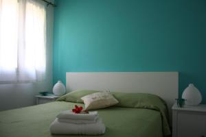 フォンターネ・ビアンケにあるVilla Mediterraneaの青いベッドルーム(タオル2枚付)