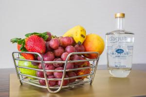 a basket of fruit next to a bottle of alcohol at Hotel MeraPrime Gold Lisboa in Lisbon