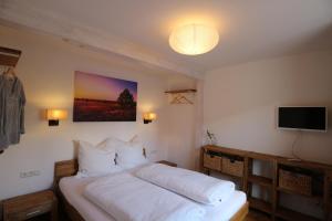 Schlafzimmer mit einem Bett und einem Flachbild-TV in der Unterkunft Ferienhaus Lüneburg in Lüneburg