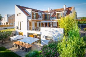 Casa bianca con tavolo e balcone di SCHEIBER Wein & Gästehaus a Weiden am See