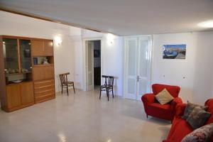 ein Wohnzimmer mit einem roten Sofa und Stühlen in der Unterkunft Casa Vienna in Salice Salentino