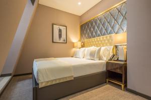 a hotel room with a bed, chair, and nightstand at Hotel MeraPrime Gold Lisboa in Lisbon