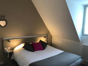 un dormitorio con una cama con dos almohadas. en Hôtel De L'Ill, en Estrasburgo
