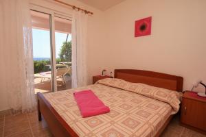 a bedroom with a bed with a red towel on it at Apartments Marketa in Gornji Dingač