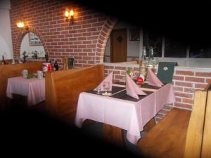a dining room with two tables and a brick wall at Pension Maestral in Mlini