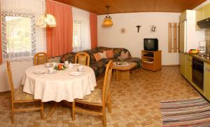 uma sala de estar com uma mesa e um sofá em Ferienwohnungen am Arber em Lohberg