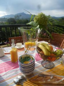 uma mesa com uma taça de fruta e um vaso de sumo em Villa La Croix Basque em Ciboure
