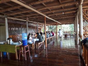 a group of people sitting at tables in a restaurant at Tres Chimbadas Lake Lodge in Tambopata