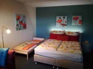 a bedroom with two beds and two paintings on the wall at Ferienwohnungen Eichenhof in Kapellen-Drusweiler