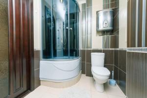 ein Bad mit einem WC und einer Glasdusche in der Unterkunft Двухкомнатная студио на Саксаганского in Kiew