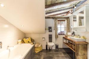 uma casa de banho com uma banheira, um lavatório e um WC. em Buxgarten Ferienhof em Oetz