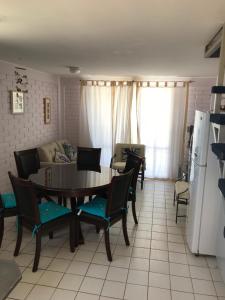 Bahia Inglesa Apartamentos في باهيا انغليسا: غرفة معيشة مع طاولة وكراسي وأريكة