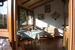 a room with a table and chairs and a couch at Villa Anna in Sorico