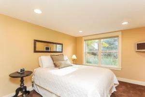a bedroom with a white bed and a window at Nightingale in Saugatuck
