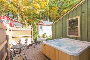 a hot tub in a backyard with chairs and a table at Nightingale in Saugatuck