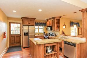a kitchen with wooden cabinets and a stainless steel refrigerator at Nightingale in Saugatuck