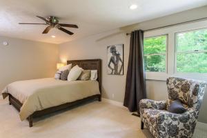 1 dormitorio con 1 cama, 1 silla y ventilador de techo en Rivers Edge, en Saugatuck