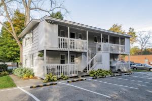 a white building with balconies and a parking lot at Water Street Retreat in Saugatuck