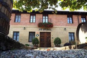 a brick building with a door and flowers on it at Casa Rural El Meson in Briones +27 photos